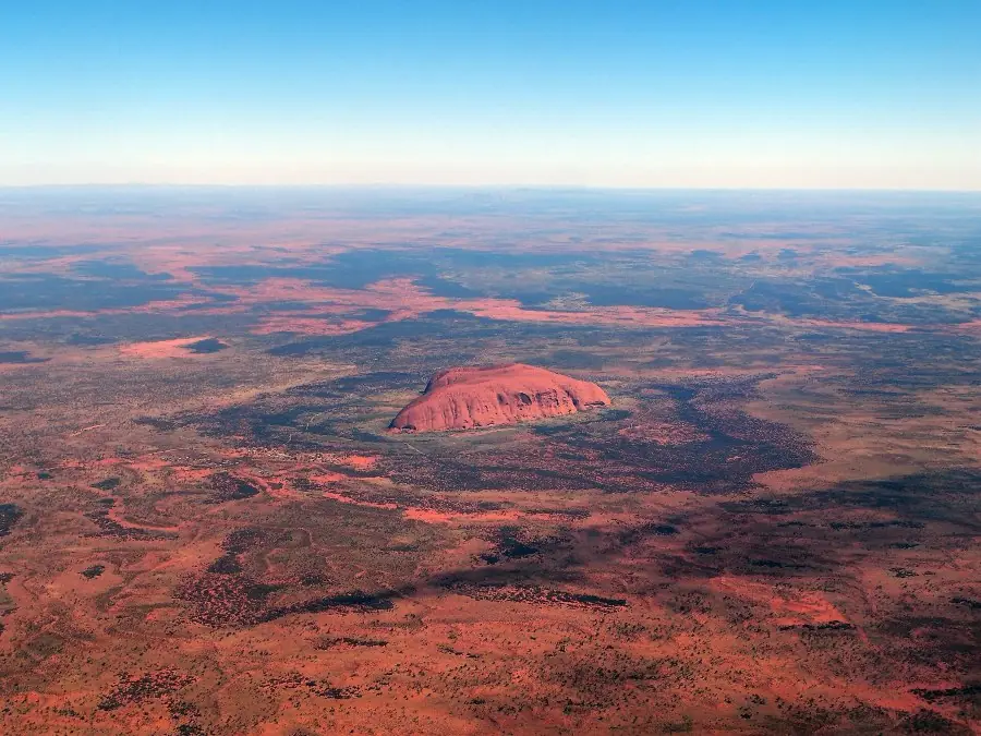 Uluru from high above, alone on the flat desert plain