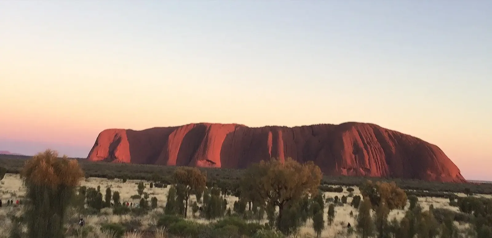 First light on Uluru with the desert plain still in shadow